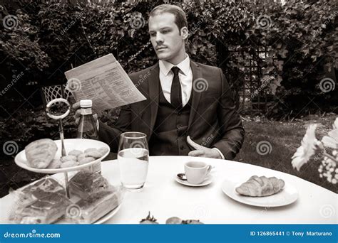 Man Dressed In Suit Drinks Esperesso At A Cafe Table Stock Image