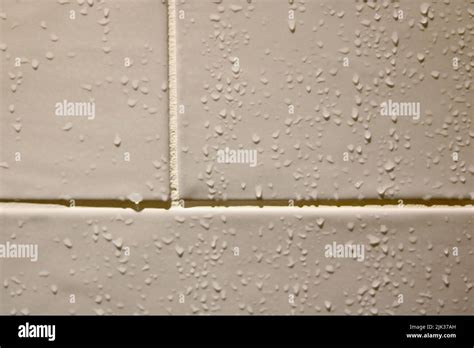 Close Up Image Of Water Droplets Running Down Beige Bathroom Tiles