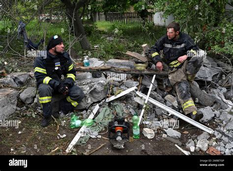 Rescuers Take A Rest At A Site Of An Apartment Building Destroyed By