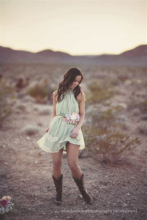 A Woman Standing In The Desert With Her Hand On Her Hip Wearing Boots