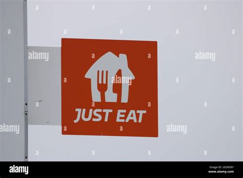 New Just Eat Logo On A Sign Outside A Takeaway Restaurant Stock Photo