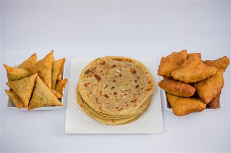 Premium Photo | Chapati mandazi andazi samosa triangularshaped snacks on a plate on a white ...