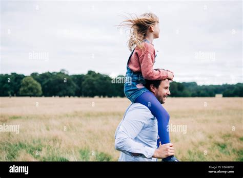 Happy Father Carrying Daughter On Shoulders At Meadow Stock Photo Alamy