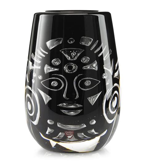 A Black Glass Vase With An Artistic Design On The Front And Sides