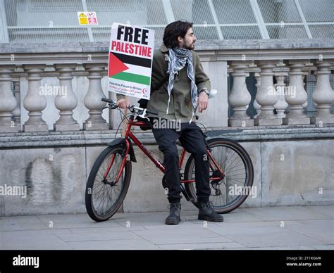 Pro Palestinian Marchers With Free Palestine Poster Sitting On Bike In