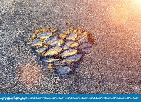 Potholes On The Asphalt In The Shape Of A Heart In The Rays Of The Sun