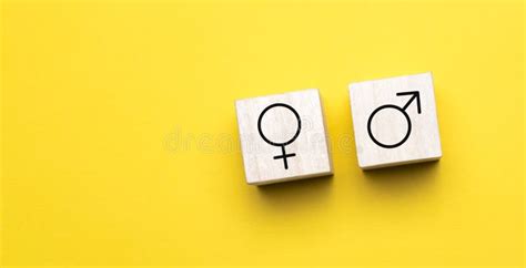 Gender Concept Wooden Blocks With Male And Female Symbols On A Seesaw On Yellow Background