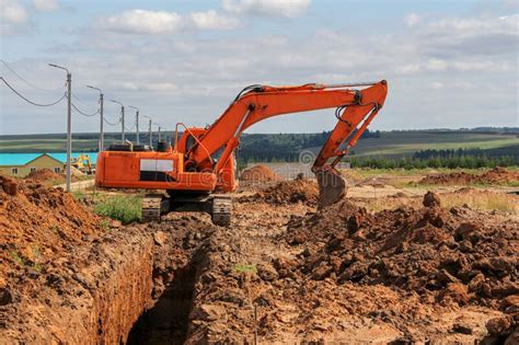 Excavator At Earthworks On Construction Site Backhoe Loader Digs A Pit