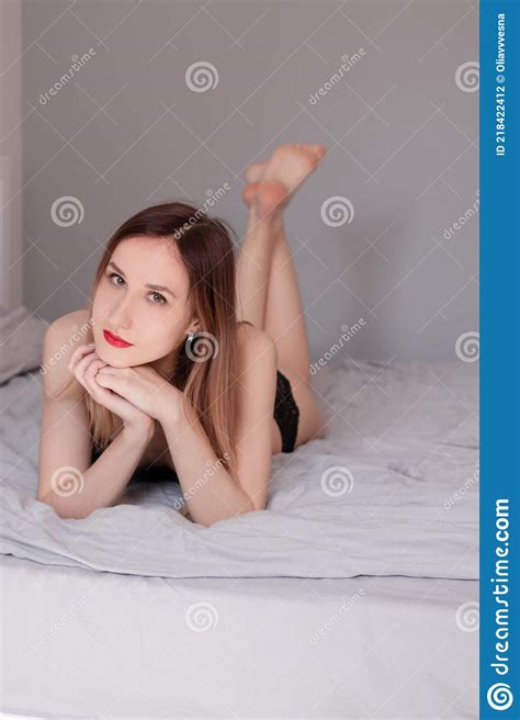 Redhead Model In Black Lingerie Is Lying On Bed With Grey Sheets Stock Photo Image Of Grey