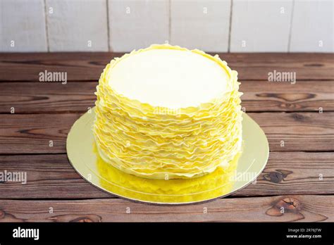 Yellow Cake With Fondant Ruffles On Rustic Wooden Background Stock