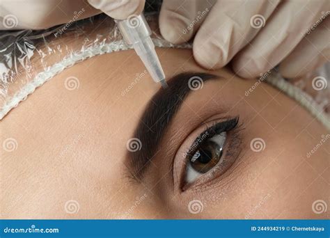 Young Woman Undergoing Procedure Of Permanent Eyebrow Makeup In Salon