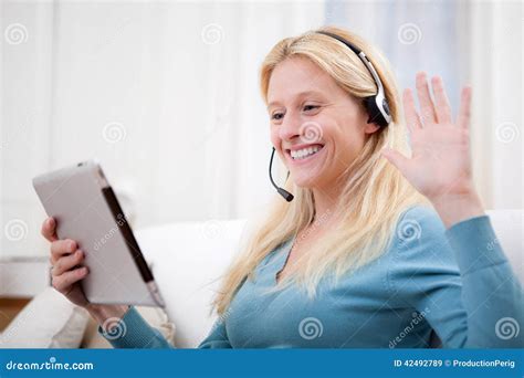 Causerie Blonde De Jeune Femme Attirante Sur Le Comprimé Image stock Image du vidéo