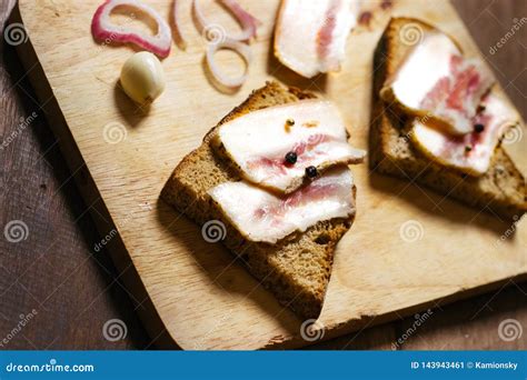 Bocadillo De La Manteca De Cerdo Con Pan Negro Y Cebollas En Un Tablero