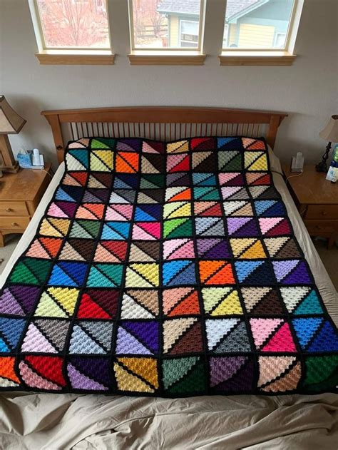 A Bed With A Colorful Quilt On Top Of It