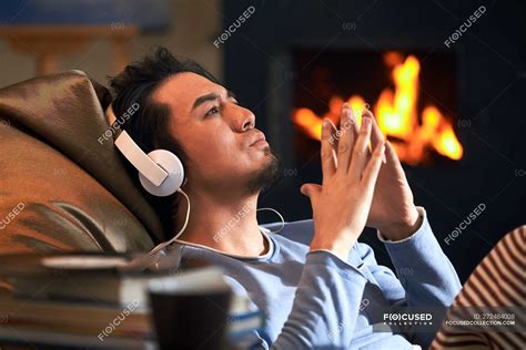 Side View Of Handsome Relaxed Man Listening Music In Headphones And