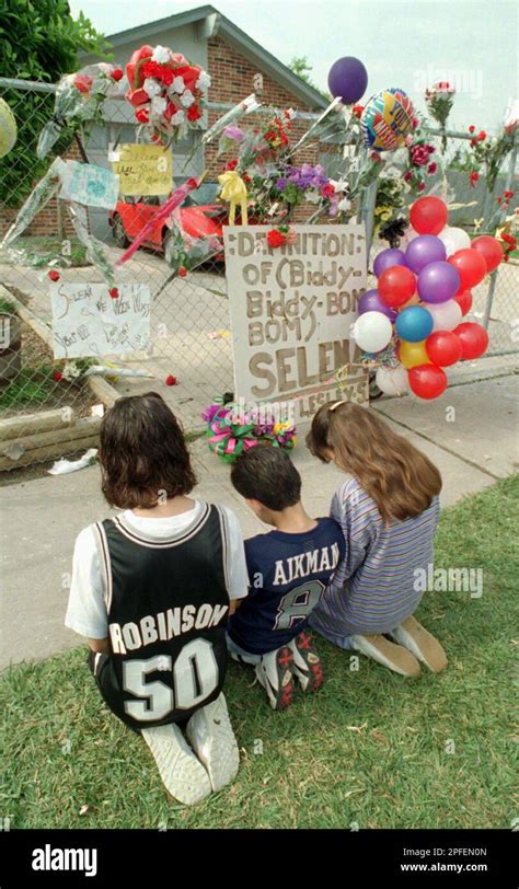 A Trio Of Young Mourners Kneel And Pray Outside The Home Of Slain