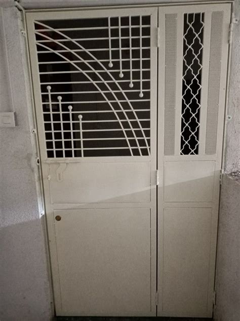 An Open White Door With Metal Bars On The Top And Bottom Doors In