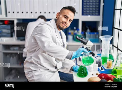 Two Men Scientists Pouring Liquid On Test Tube At Laboratory Stock