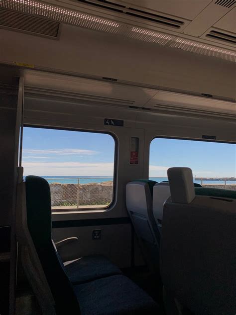 The Inside Of A Train With Two Windows Looking Out At The Ocean And