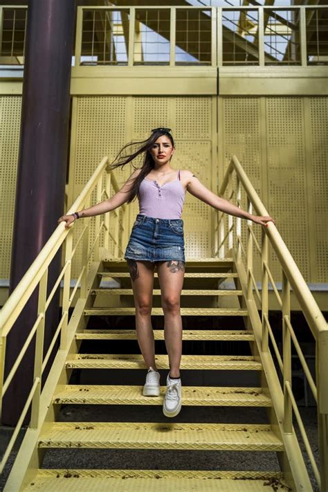 Foto Vertical De Una Joven Caucásica Posando En La Escalera Amarilla De