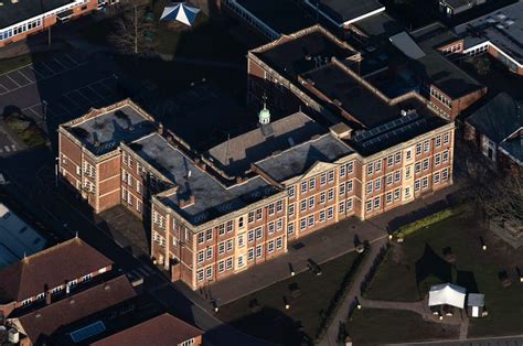 an aerial view of a large brick building with many windows and roofing on it