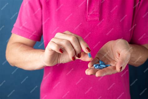 Premium Photo A Woman Holds A Blue Pill In Her Hand Against A Blue