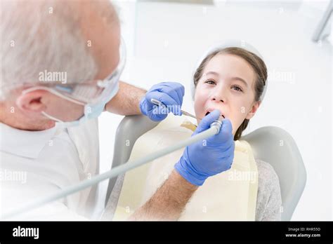 Dentist Examining Patient With Dental Equipment At Clinic Stock Photo