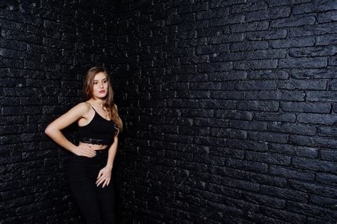 Premium Photo Handsome Brunette Girl Wear On Black Posing At Studio Against Dark Brick Wall
