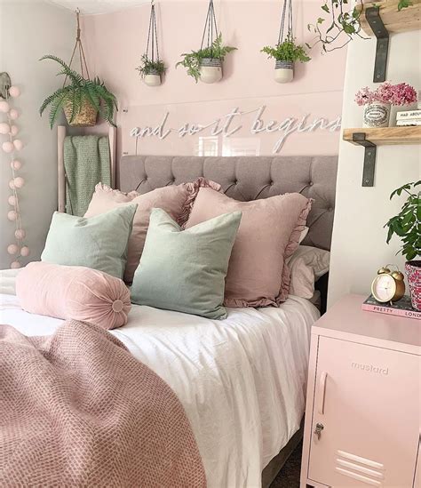 A Bed With Pink And Green Pillows On Top Of It Next To A Wall Mounted