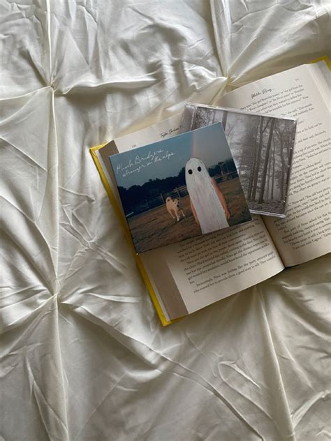 An Open Book Sitting On Top Of A Bed Next To A White Sheet Covered Ground