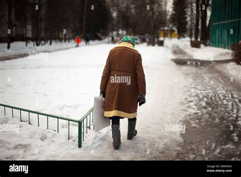 Russian pensioner walks down street in winter. Old woman in Russia ...