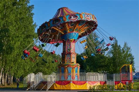 People Ride The Chain Carousel In An Amusement Park Cheboksary Russia