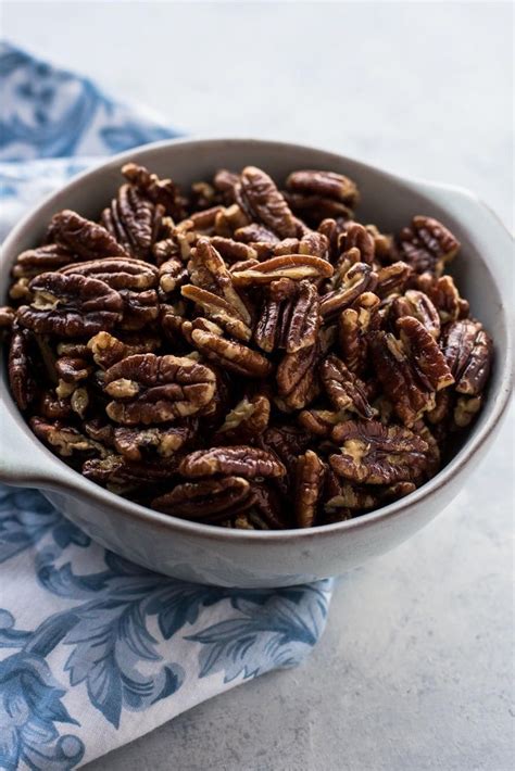 a bowl filled with pecans sitting on top of a blue and white towel