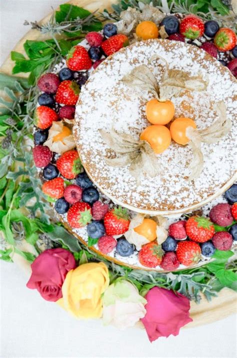 A Cake Covered In Powdered Sugar Surrounded By Fresh Fruit