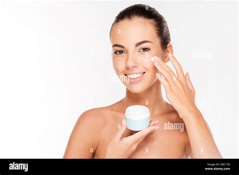 Portrait Of Young Woman Applying Moisturizer Cream On Her Face Isolated