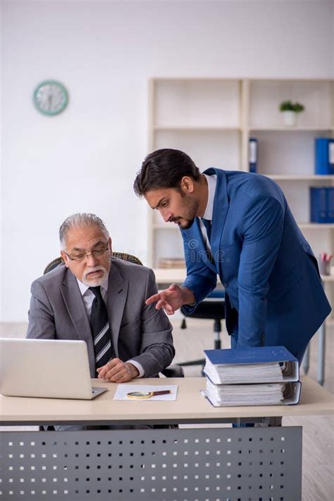 Jefe Masculino Viejo Y Empleado Joven Que Trabaja En La Oficina Foto De