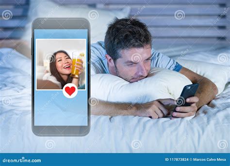 Young Attractive Man Lying In Bed On Line Searching For Sex Or Love