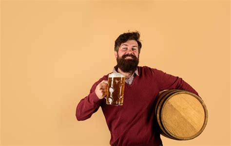 Premium Photo Bearded Man Hold Glass And Barrel With Craft Beer