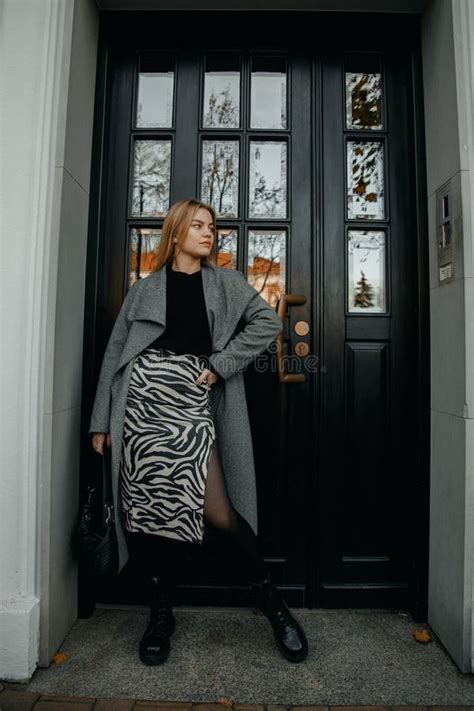 Stylish Girl Standing In The Front Of Old Massive Wooden Door A