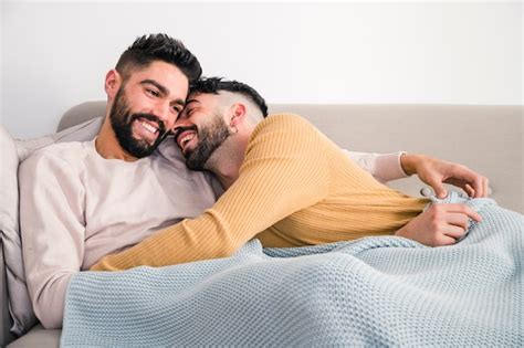 Primer plano de romántico joven pareja gay acostado en sofá Foto Gratis