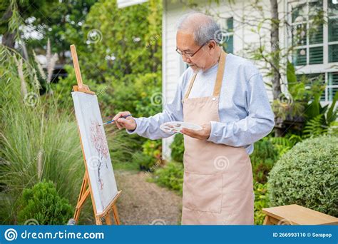 Asian Senior Old Man Painting Picture Using Brush And Oil Color On