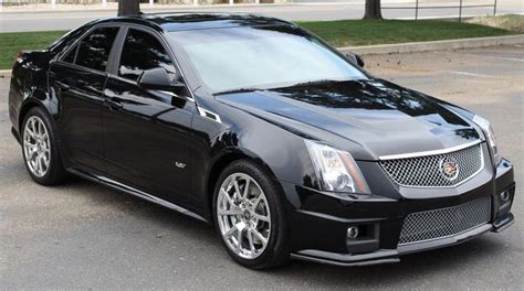 A Black Cadillac Parked In A Parking Lot