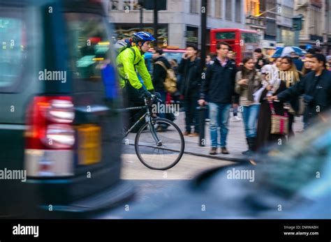 Cyclist Going Through Oxford Circus During Rush Hour London Stock