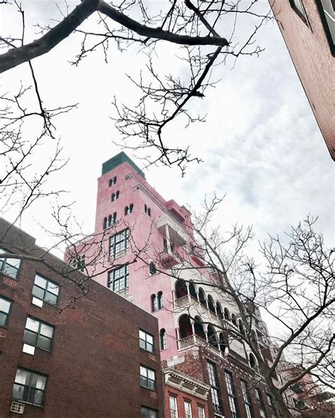 An Old Brick Building With Many Windows And Balconies On The Top Floor