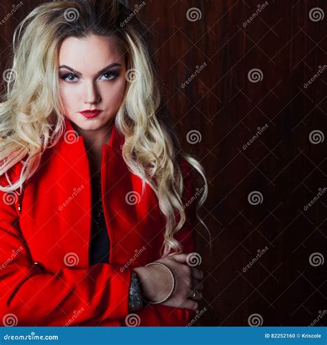 Junge Und Attraktive Blonde Frau In Der Roten Jacke Rostige Wand Des Hintergrundschmutzes