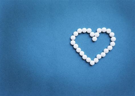 Premium Photo Heart Shaped Pills On A Blue Background