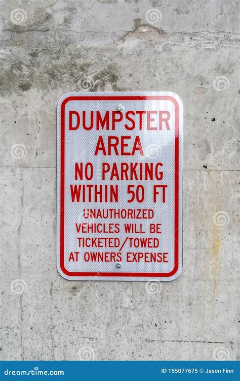 Close Up Of A Sign That Reads Dumpster Area No Parking Against A