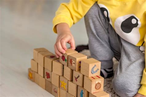 Premium Photo | Child building stack of wood cube building blocks