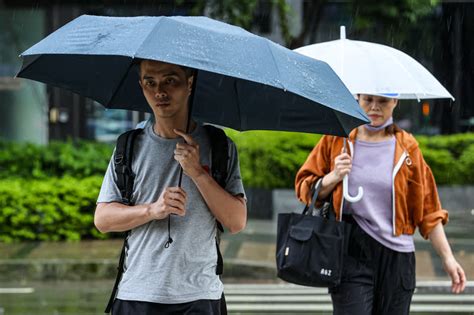 新北午後陣雨 民眾撐傘過馬路 圖