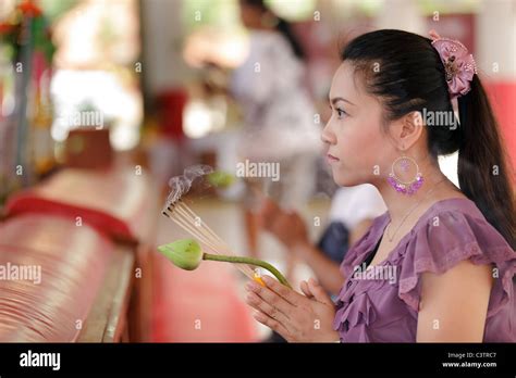 Young Asian Thai Woman Praying Buddha With Lotus Flower And Incense